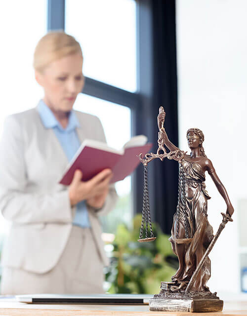 Tax Attorneys Dallas studies law in office with themis stature in foreground